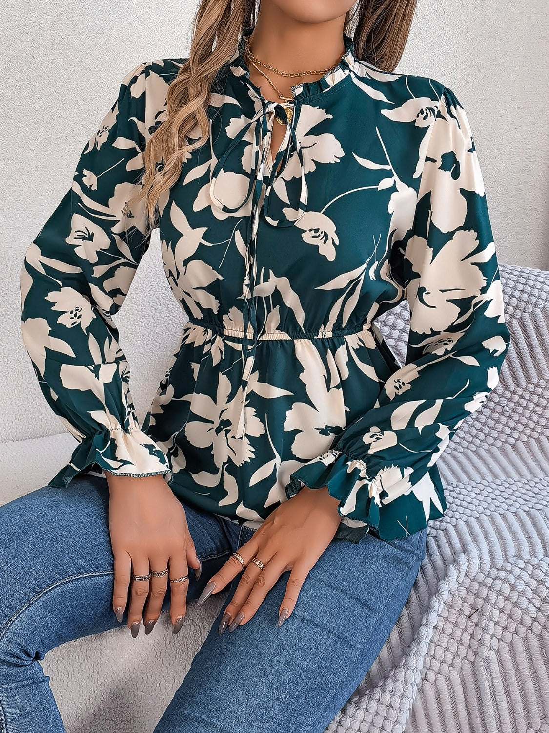 Deep Teal floral peplum blouse with ruffled neck and tie detail.