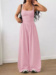 Pink ruched wide-leg jumpsuit with spaghetti straps and a square neckline.