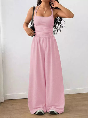 Pink ruched wide-leg jumpsuit with spaghetti straps and a square neckline.
