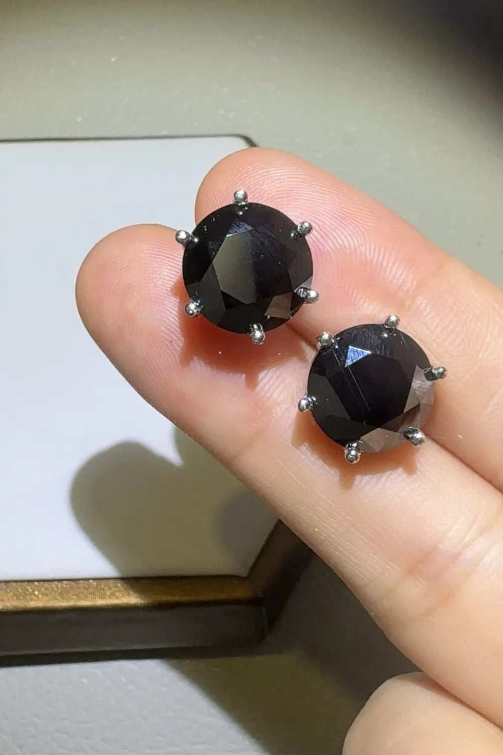 Black moissanite stud earrings with six-prong setting.