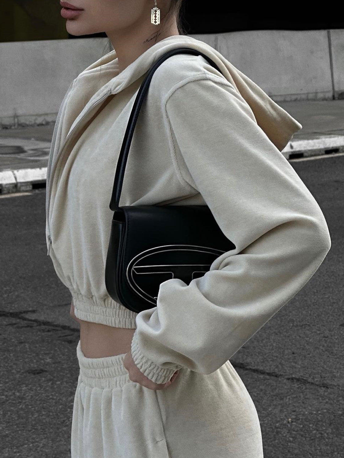 Apricot cropped zip hoodie and wide leg sweatpants set with a black shoulder bag