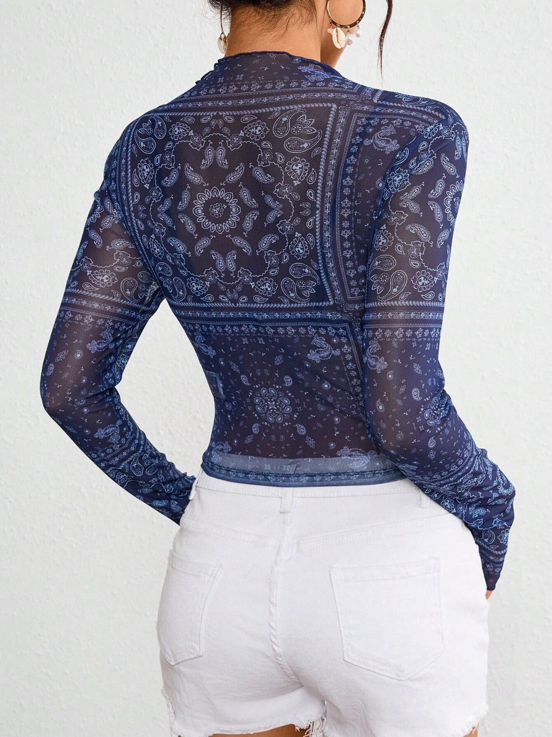 Dark blue mesh mock neck top with bandana print and long sleeves.