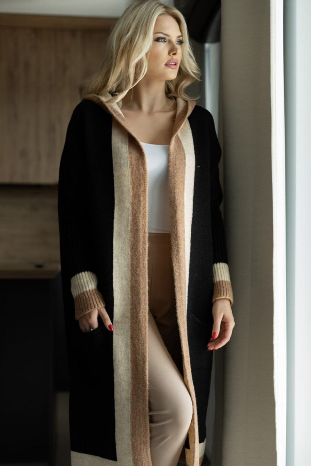 Color-blocked hooded knit maxi cardigan in black with tan and cream stripes, featuring ribbed cuffs.