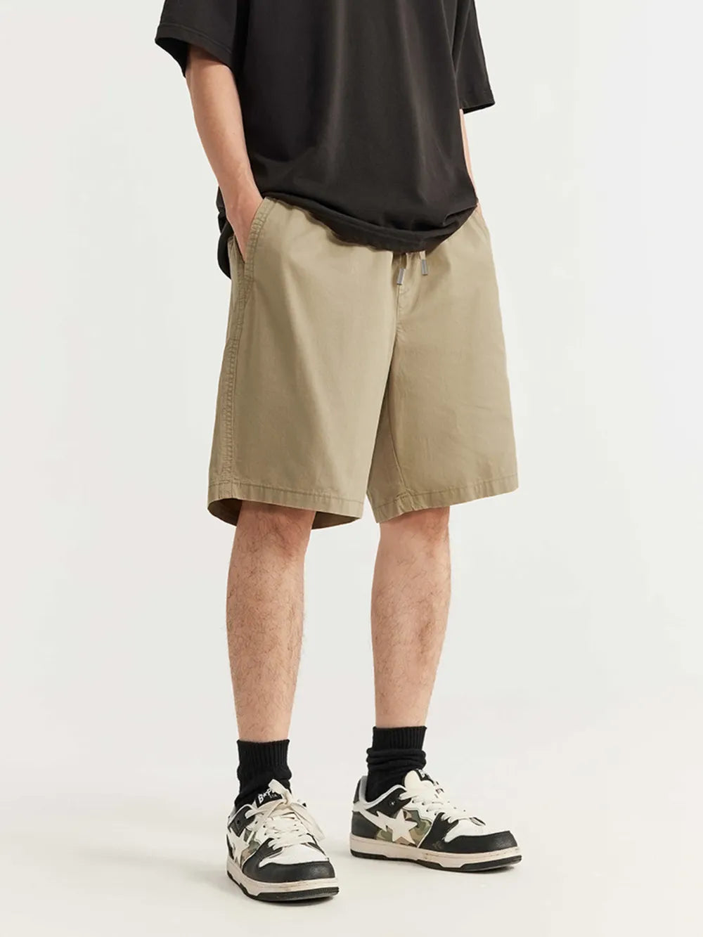 Men's khaki chino shorts with drawstring waist and knee-length cut.