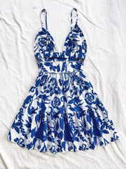 Vibrant floral v-neck mini dress with cutout back and tiered skirt.