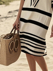 Striped midi dress with half sleeves in black and tan, worn casually at the beach.