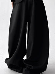 Men's black wide leg drawstring sweatpants with a relaxed fit.