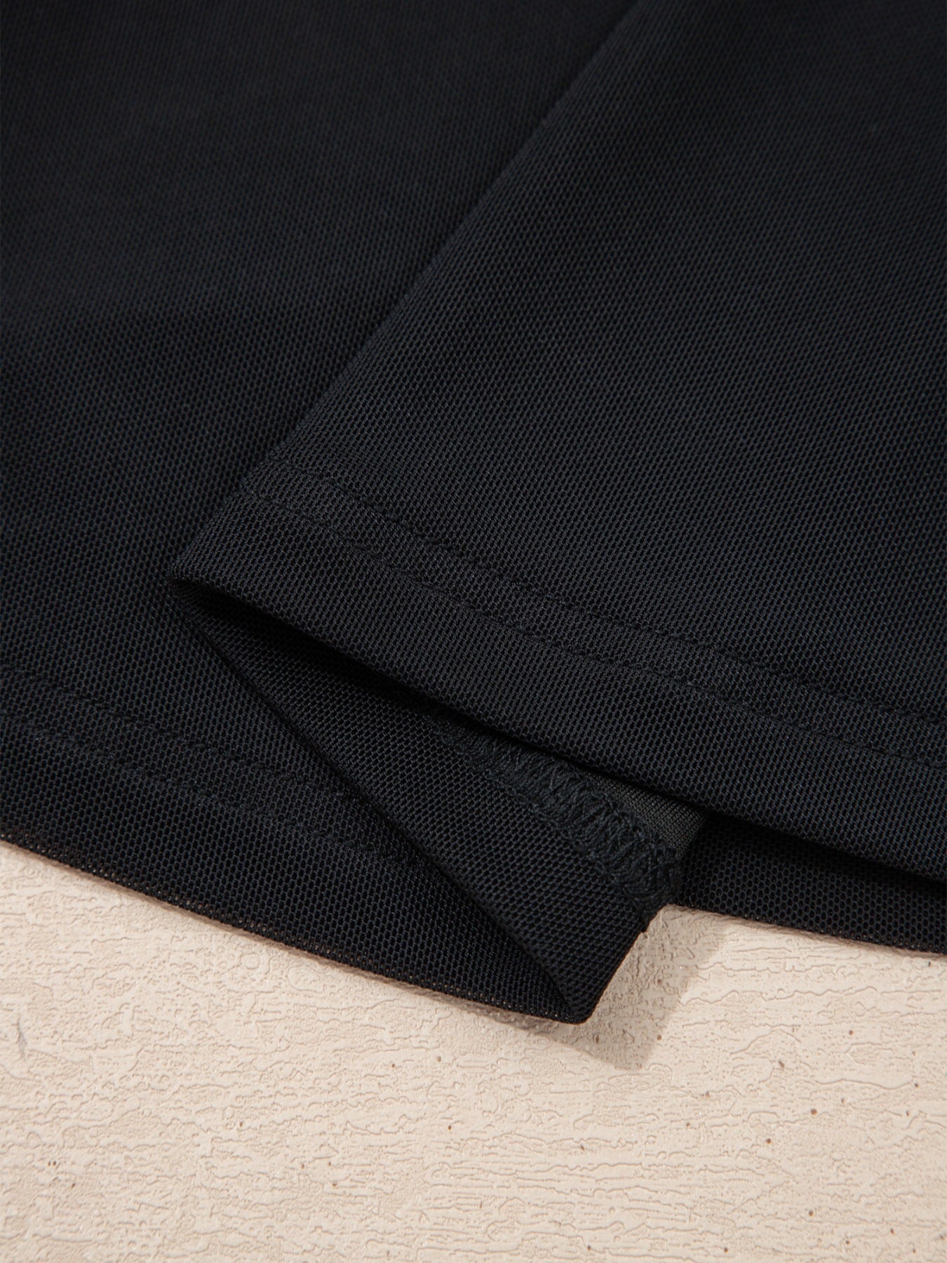 Black sheer mesh t-shirt with cap sleeves, showing fabric texture and seams.