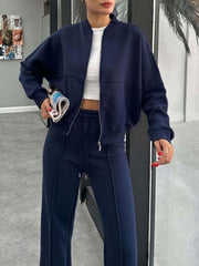 Dark blue bomber jacket and wide-leg tracksuit with white crop top.