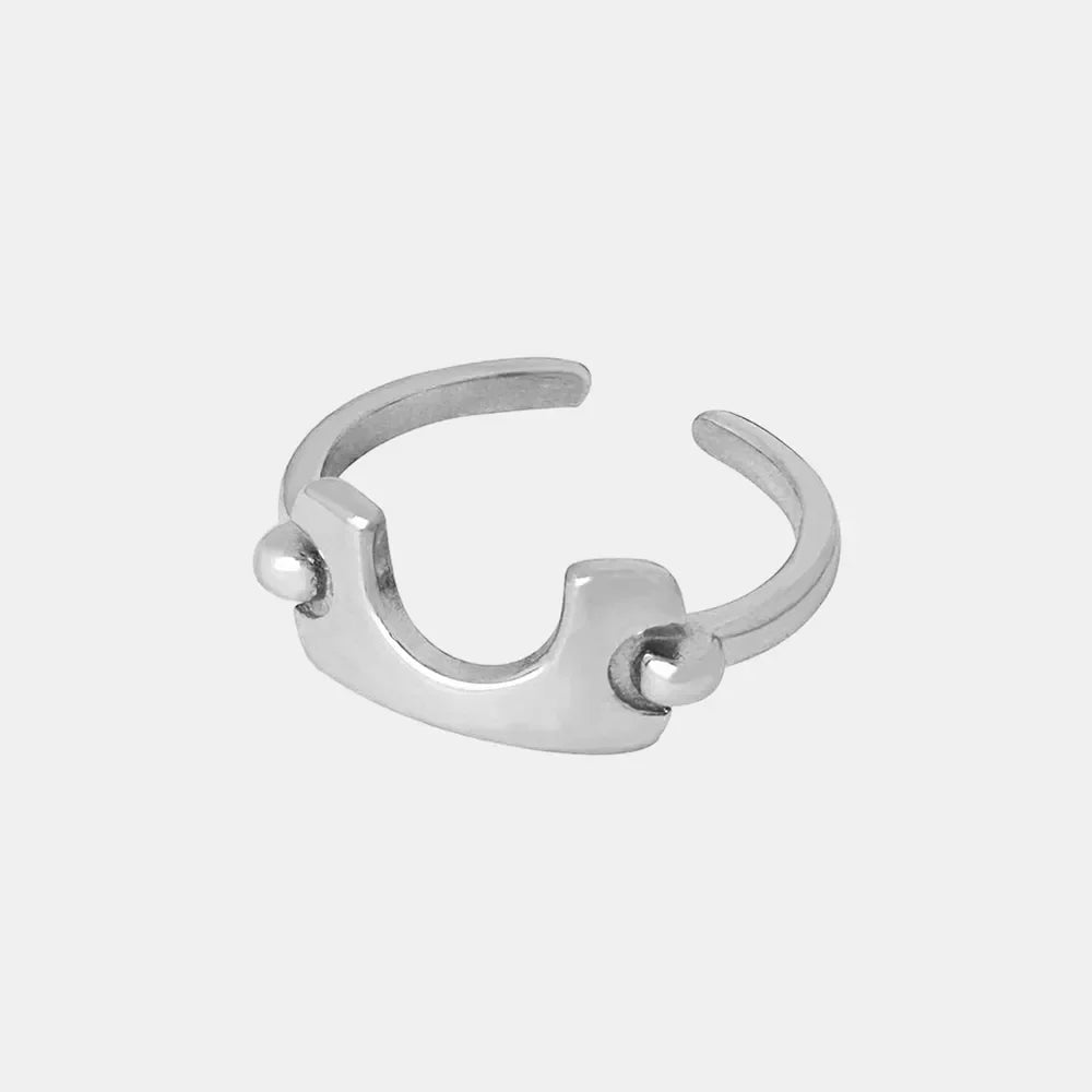 Sculptural silver open-ended ring with asymmetrical design and ball details.