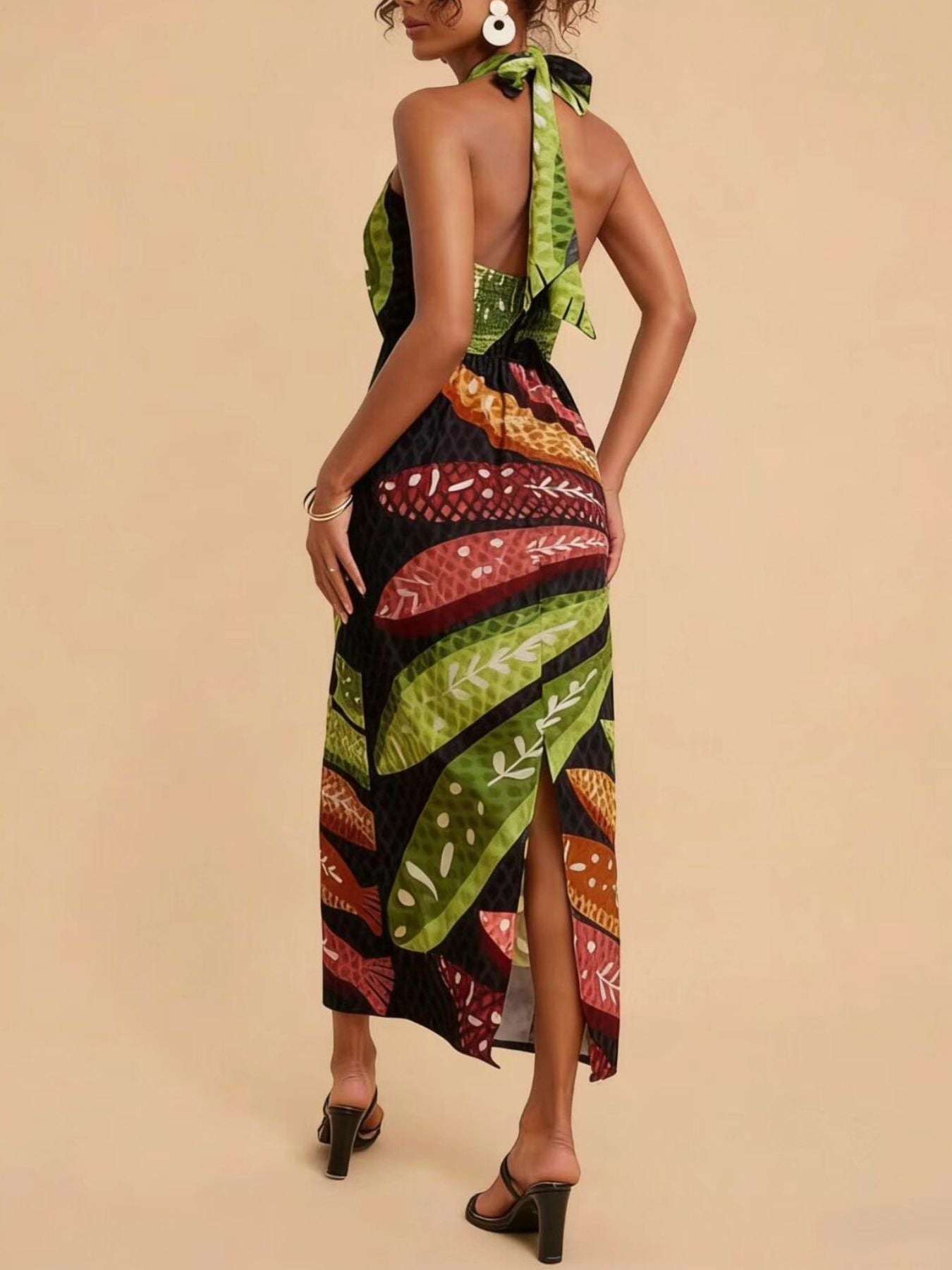 Tropical print halter neck midi dress with a side slit and tie back detail.