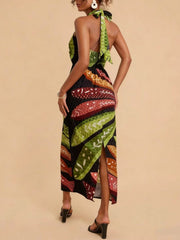 Tropical print halter neck midi dress with a side slit and tie back detail.