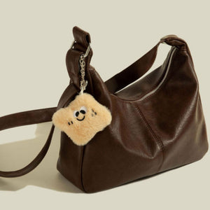 Brown crescent shape pu leather shoulder bag with fuzzy charm