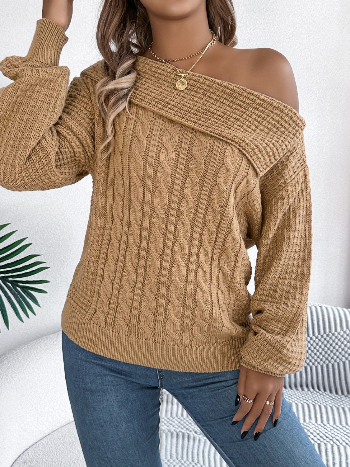 Camel off-shoulder cable knit pullover sweater with asymmetrical neckline and ribbed details.