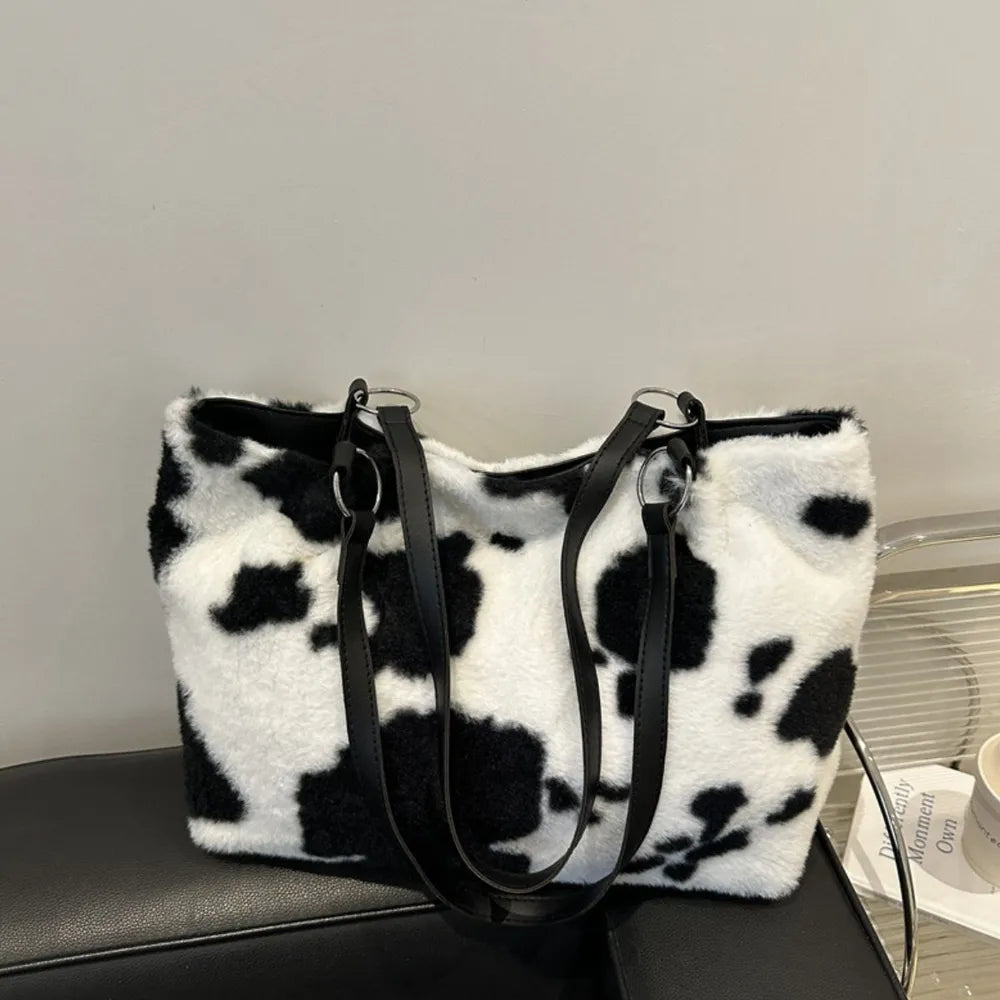Cowhide print faux fur shopper bag with black faux leather straps and silver hardware.