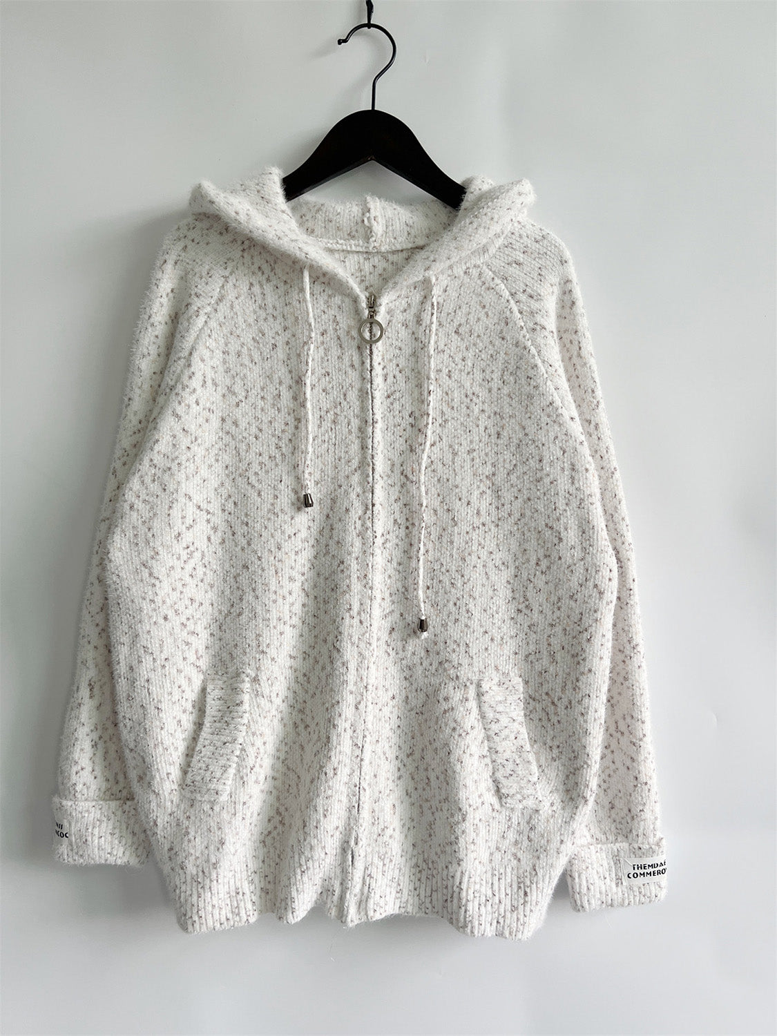 White speckled knit relaxed zip-up hoodie with ring zipper and drawstring hood.
