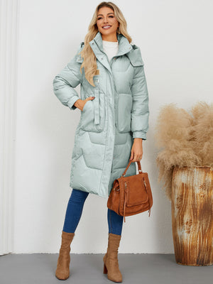 Sage quilted puffer parka with buckle detail and hood, full length.