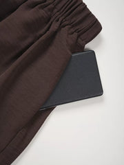 Chocolate wide-leg pants with elastic waistband and side pocket detail.