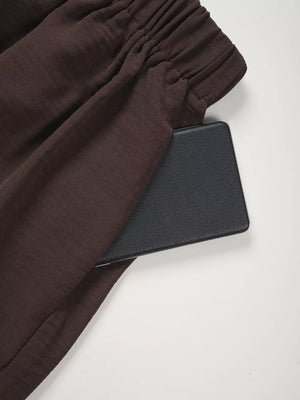 Chocolate wide-leg pants with elastic waistband and side pocket detail.