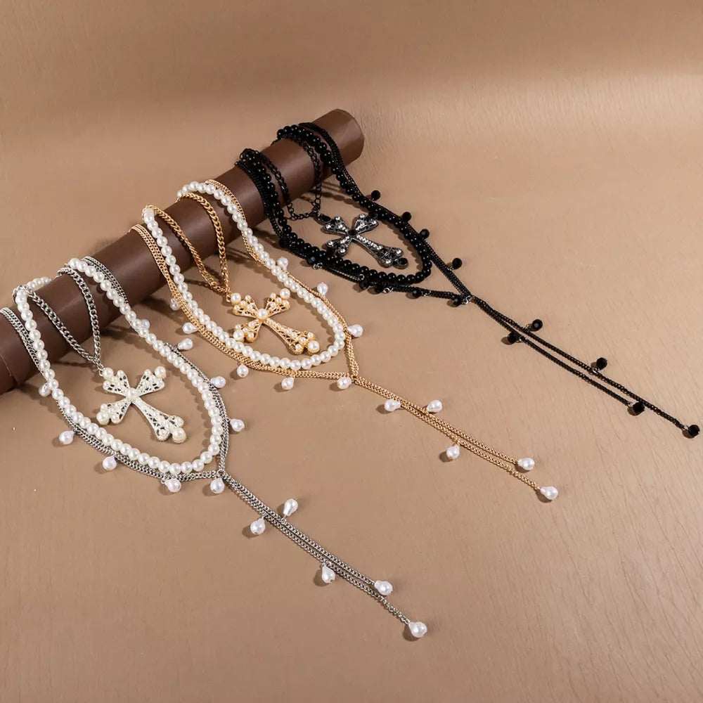 Pearl cross pendant necklaces in silver, gold, and black with dangling pearl accents.