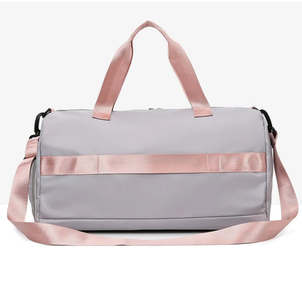 Gray duffel bag with pink straps and buckle detail, perfect for gym or travel.