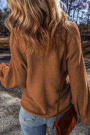 Brown ribbed knit pullover sweater with balloon sleeves and a casual fit.