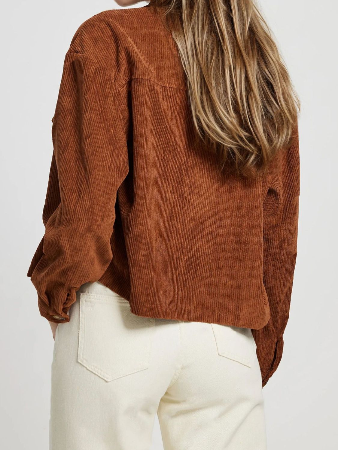 Brown corduroy utility jacket with buttoned cuffs and patch pockets.