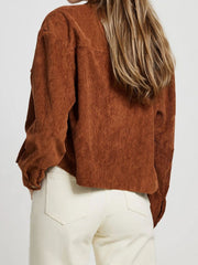 Brown corduroy utility jacket with buttoned cuffs and patch pockets.