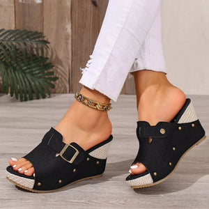 Black wedge sandals with decorative gold studs and buckle detail.