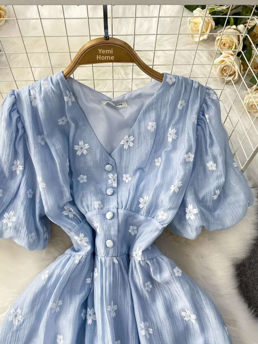 Light blue embroidered puff sleeve midi dress with V-neck and button front.