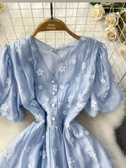 Light blue embroidered puff sleeve midi dress with V-neck and button front.