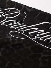 Black leopard print sweatpants with white script embroidery detail.