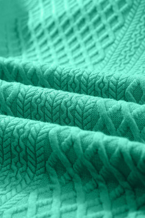 Turquoise textured trapeze dress with ruffle sleeves and a subtle geometric pattern.