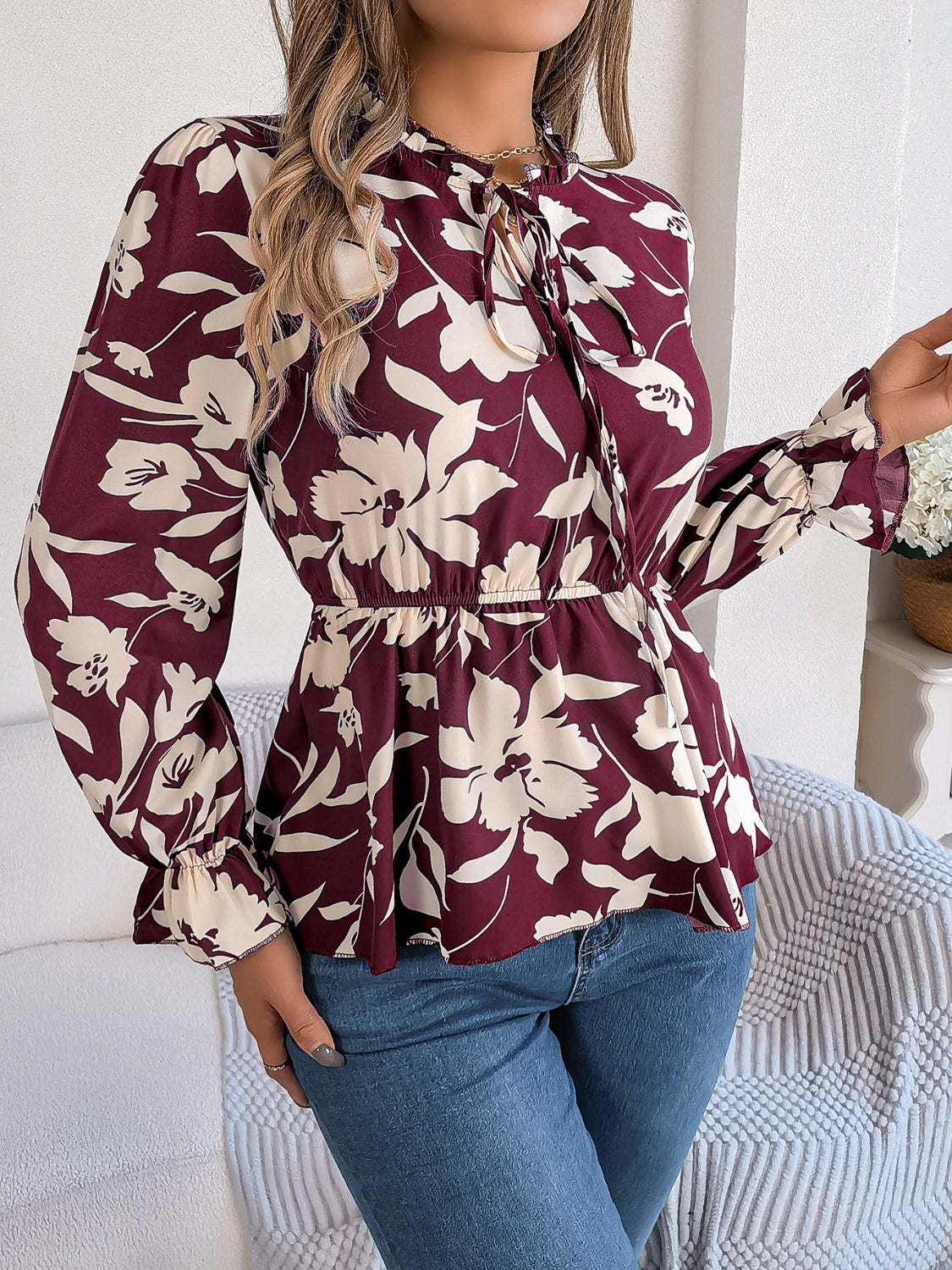 Burgundy floral peplum blouse with ruffled tie-neck and bell sleeves