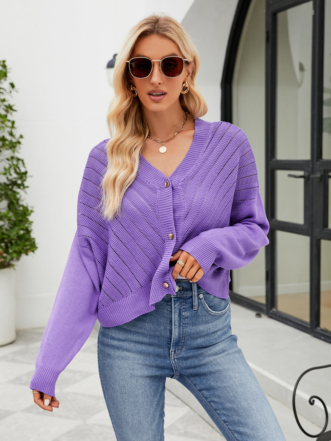 Purple cropped V-neck knit cardigan with button front and open knit detail.