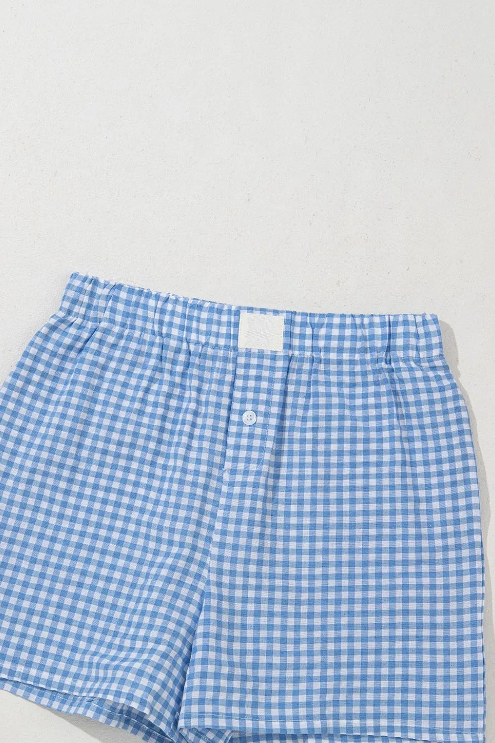 Light blue gingham boxer shorts with elastic waistband and button fly.