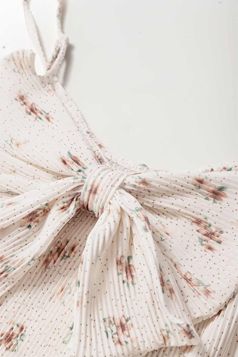 Pleated floral tank top with a bow detail on the back.