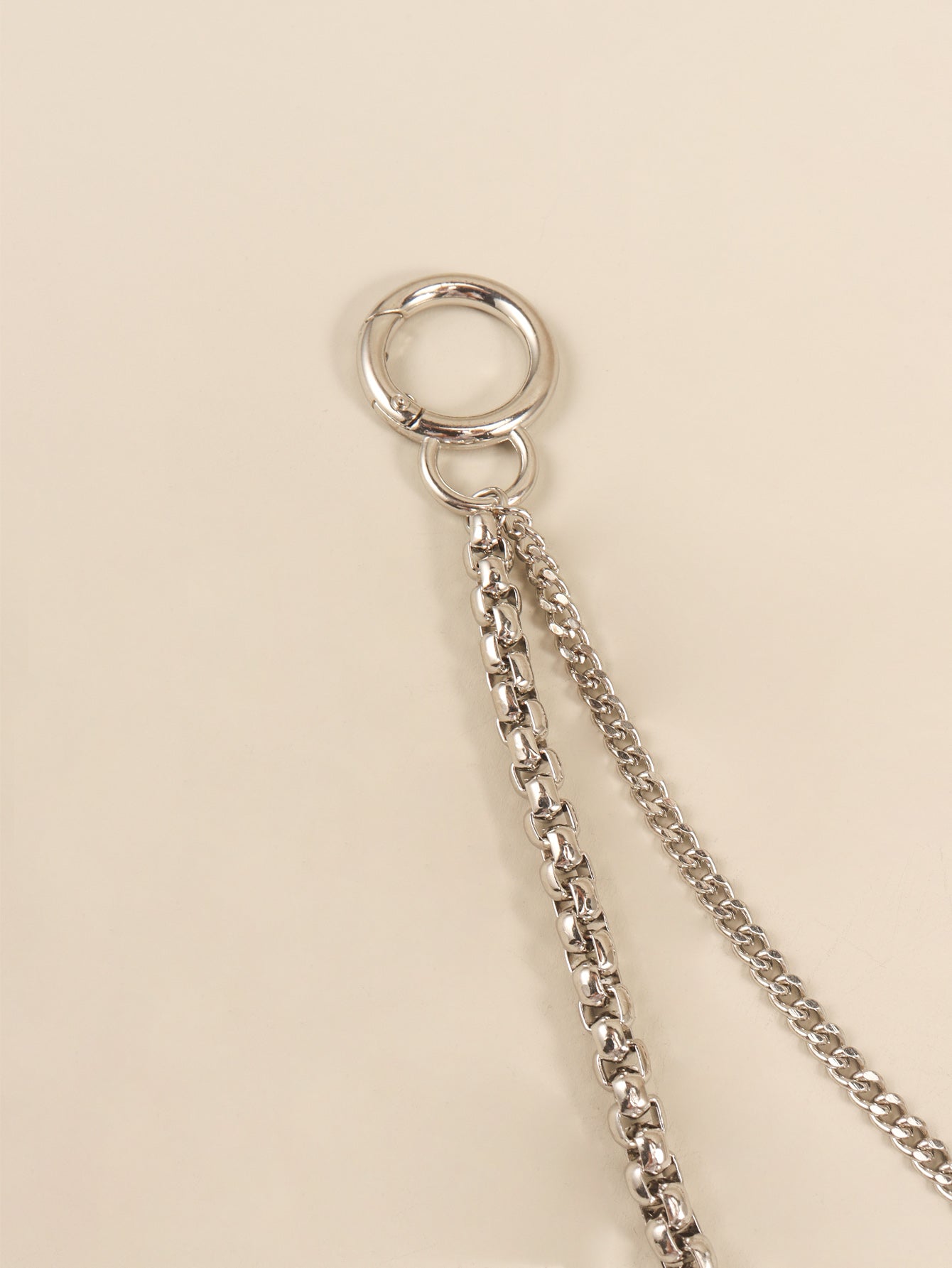 Silver double-strand chain accessory with a large O-ring and carabiner clasp.