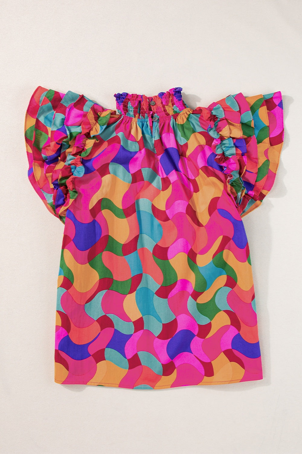 Kaleidoscope ruffle sleeve smocked blouse in hot pink with a colorful abstract pattern.