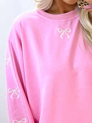 Pink loungewear set with embroidered white bows on the chest and sleeves.