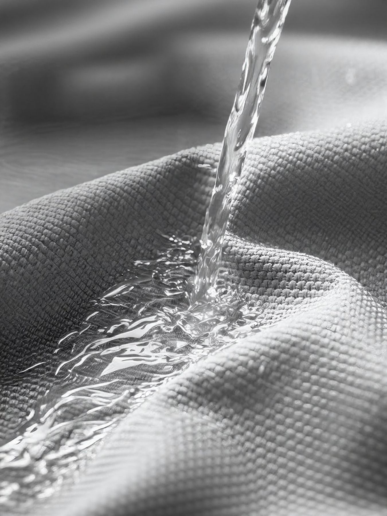 Gray pet carrier fabric repelling water, showing breathable material.