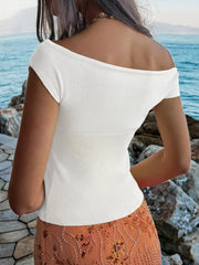 White off-shoulder knit top with short sleeves and a ribbed waistband.