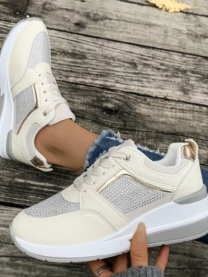 Beige platform sneakers with gemstone panel details and gold accents.