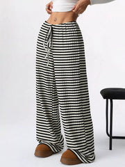 Striped ribbed wide-leg pants with drawstring waist and black and white horizontal stripes.