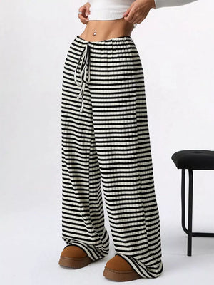 Striped ribbed wide-leg pants with drawstring waist and black and white horizontal stripes.