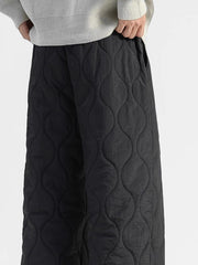 Black quilted sweatpants with relaxed fit and side pockets.
