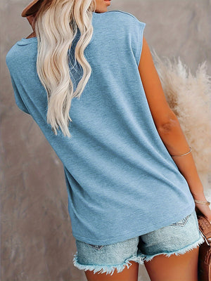 Light blue relaxed tee with cap sleeves and a pocket detail, worn with denim shorts.