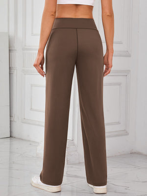 Brown wide-leg lounge trousers with a high waist and straight leg, styled with sneakers.