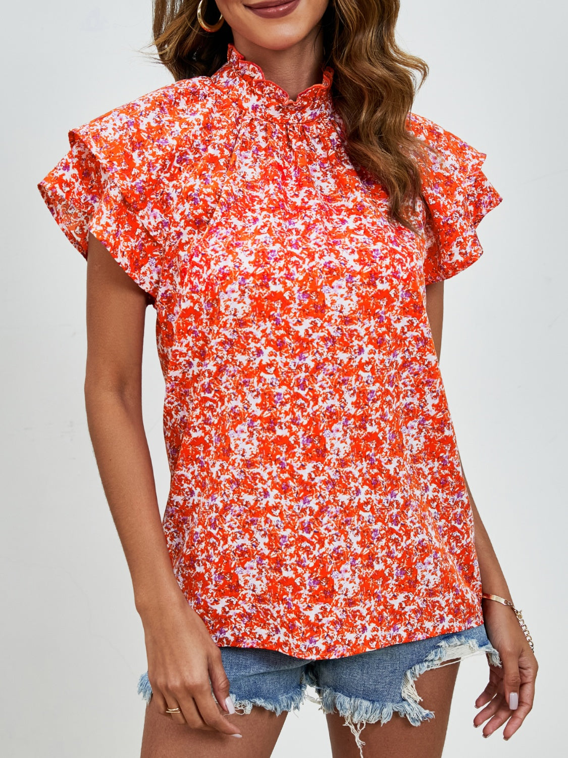 Orange floral blouse with ruffled neckline and flutter sleeves