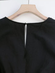 Black cotton romper with button-down detail and keyhole back.
